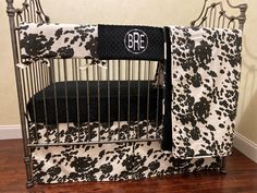 a black and white crib bedding set with monogrammed design on it