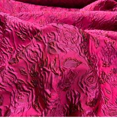 pink fabric with intricate designs on it