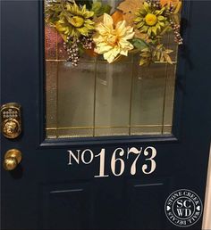 the front door is decorated with flowers and numbers