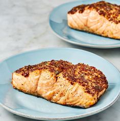 two blue plates with cooked salmon on them