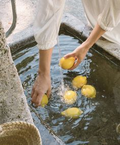 a person is pouring lemons into the water