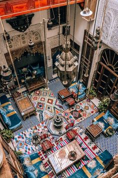 an overhead view of a living room with blue and white tiles on the floor, furniture and rugs