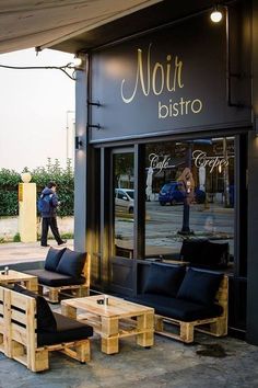 the outside of a restaurant with wooden benches and tables