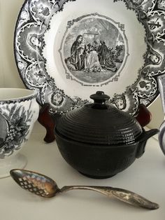 there is a teapot, spoon and plate on the table