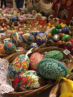 several baskets filled with colorfully painted eggs on top of a table next to each other