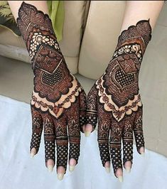 two hands with henna designs on them, one is showing off the intricate design