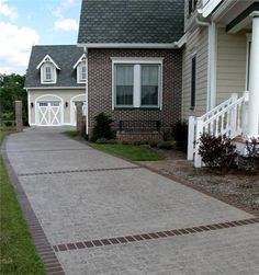 a brick driveway leading to a house