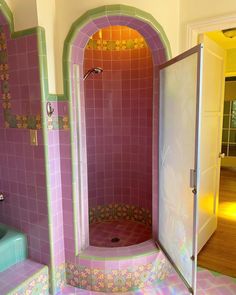 a bathroom with purple tiles and pink walls