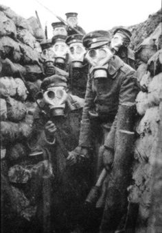 some people wearing gas masks are standing in a trench