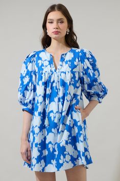 Stay fresh while looking cute in the Grafton Floral Chila Babydoll Mini Dress. Long sleeves frame a split neckline with a tie tassel in the front. Small pleats lead to a babydoll effect which makes is comfortable to move around it. You can easily pair it up with white heels or sandals. - Split neck- Mini dress- Floral- Pocket- Color: Blue MulSize + Fit - Model is 5'10" and wearing size XS- Measurements taken from size S - Chest: 20 1/2"- Length: 34 1/2" Fabric Self: 100% Cotton, Lining: 97% Poly Spring Dresses With Back Tassel Tie-up, Blue Split Neck Beach Dress, Spring Beach Dress With Tie Neck, Spring Daywear Dress With Tie Neck, Blue Tie-neck Summer Dress, Blue Tie Neck Dress For Spring, Blue Split Neck Spring Dress, Blue V-neck Dress With Tassels, Spring Cotton Dresses With Tassels