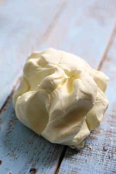 a piece of white cake sitting on top of a wooden table next to a knife