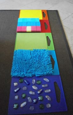 an orange f is on the floor next to some blue and green rugs with different colors