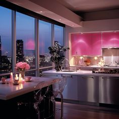 a kitchen with pink cabinets and lights on the counter tops, along with candles in vases