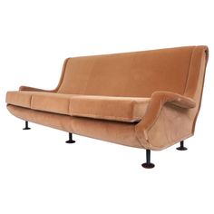 a brown couch sitting on top of metal legs