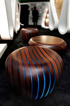 two wooden stools sitting on top of a black carpet