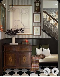 a living room with black and white checkered flooring next to a stair case