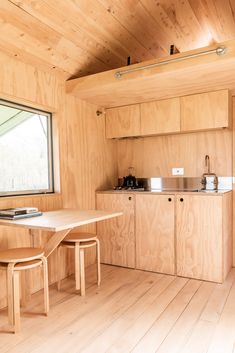 a kitchen with wooden walls and flooring next to a window