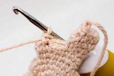 a crocheted object is being worked on with scissors