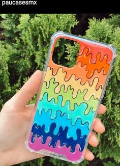 a hand holding up a phone case with colorful liquid paint on the back of it