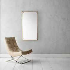 an empty chair in front of a mirror on the wall with a white tile floor