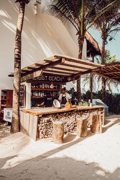 an outdoor bar on the beach with palm trees