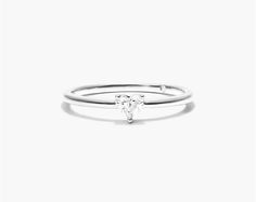 a white gold ring with a single diamond in the middle, on a white background