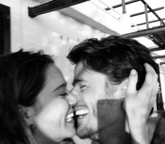 a man and woman are laughing together in black and white