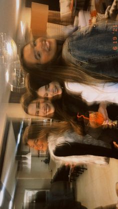 three young women are standing in front of a mirror