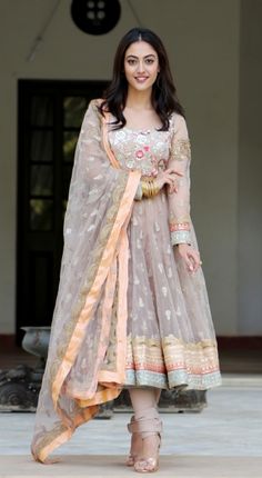 a woman in a dress standing on the sidewalk