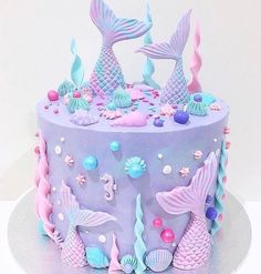 there is a cake decorated with mermaid decorations