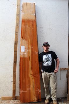 a man standing next to some wooden boards