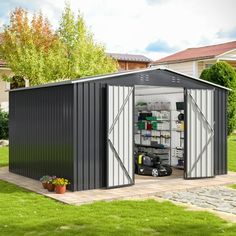 a metal storage shed with the doors open and shelves on the side, in front of a house