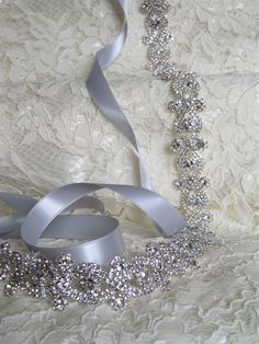 "Sparkling silver bridal sash adorned with rhinestones. Securely fastened onto a quality double faced satin ribbon which ties into a bow and drapes down the back of your wedding dress. Perfect finishing touch for your wedding attire! Please make your choice of rhinestone trim length, ribbon colour, no ribbon or hook and eye closure from the drop down menus. Contact me if you have a custom length requirement. Ribbon options to purchase: You may purchase just the rhinestone trim ( no ribbon ) The Wedding Sash Belt, Wedding Sash, Wedding Belts, Bridal Sash, Belt Style, Rhinestone Trim, Bridal Belt, Rhinestone Bridal, Beaded Trim