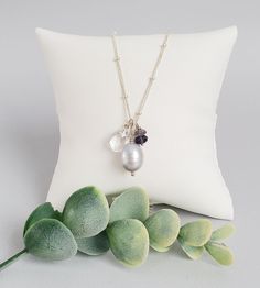 Wear both shimmer and sparkle with this gray pearl iolite cluster pendant. A beautiful freshwater pearl, with silvery luster, is surrounded by sparkling gemstones. A small stack of classic blue iolite and a clear drop of quartz draw the eye with pretty faceting.



Floating over beaded chain, this pendant securely closes with dainty beads and handmade hook clasp. It's a timeless, detailed piece you're sure to wear again and again. Freshwater Pearl Jewelry, Gemstone Necklaces, Cluster Pendant, Fashion Hair Accessories, Hook Clasp, Delicate Jewelry, Accessories Handmade, Pearl Grey, Dainty Jewelry