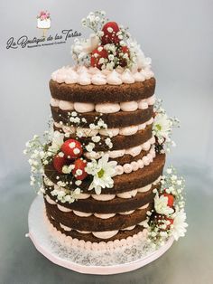 a three tiered cake is decorated with flowers and berries