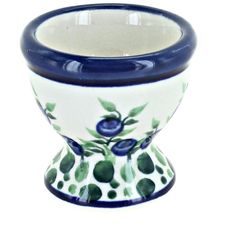 a blue and white vase with green leaves on it's rim is shown against a white background