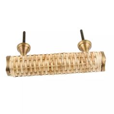 two brass - plated hooks are attached to a bamboo curtain rod and hang on a white background