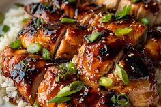 chicken with sesame seeds and sauce on top of rice