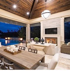 a dining room table with candles on it in front of a large window overlooking a swimming pool