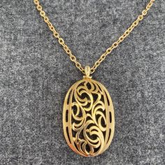 This exquisite vintage necklace features an intricate filigree design on an oval pendant, exuding timeless elegance. Perfect for adding a touch of sophistication to any outfit. * Gold-tone metal * Filigree oval pendant * Chain with spring ring clasp * Pendant: 2 inches long * Chain: about 28 inches long top to bottom = 28 inches Elegant Oval Link Locket Necklace, Elegant Gold Filigree Locket Necklace, Ornate Oval Pendant Necklaces For Formal Occasions, Ornate Oval Pendant Necklace For Formal Events, Antique Filigree Oval Pendant Necklace, Oval Filigree Necklaces For Formal Occasions, Elegant Oval Pendant Locket Necklace, Formal Oval Filigree Necklace, Gold Filigree Oval Pendant Necklace