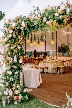 the inside of a tent decorated with flowers and greenery