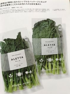 two bags of green vegetables sitting on top of a white table next to each other