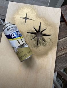 a can of beer sitting on top of a wooden table next to a star cutout