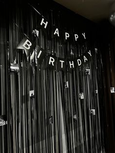 a black and white photo of a birthday party with streamers on the wall that says happy bj's birthday