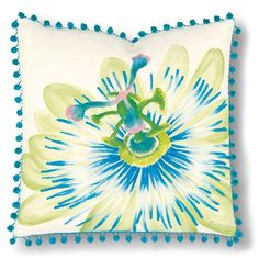 a blue and yellow flower pillow with pom - poms on the bottom, in front of a white background