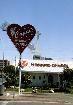 a wedding chapel with a large heart shaped sign in front of it's building