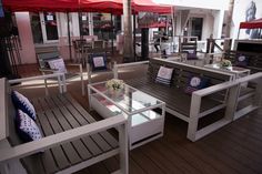 an outdoor seating area with tables, chairs and umbrellas