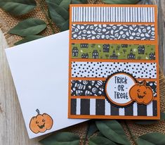 two cards with pumpkins on them sitting next to some green leaves and paper that says trick or treat