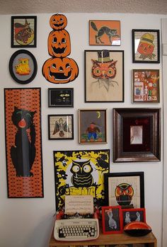 the wall is covered with many halloween pictures and pumpkins, including an old typewriter