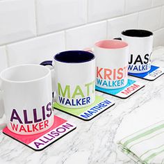 three coffee mugs sitting on top of a counter next to each other in front of a white tiled wall